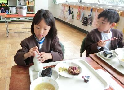 牛乳びんのふたを開けようとする小学1年生