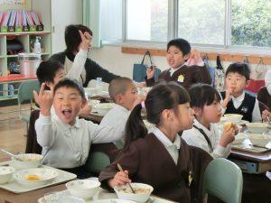 子供達がご飯を食べながら、クイズをしている写真