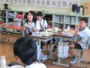 学生たちは給食を食べながら、話を聞いている写真