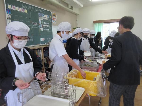 きちんとエプロンをつけて配膳をする村立中学校2年生