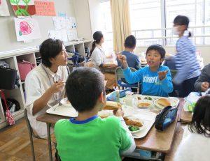 調理員さんと一緒に給食を食べる生徒たちの写真