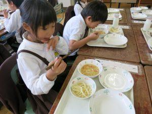 子供がめんをおはしで食べている写真2