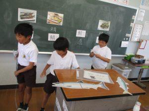 学生たちが鮭クイズと魚の漢字のお話をしている写真