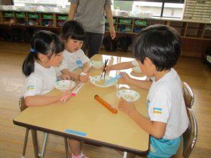 子供達はマイ箸を使って、お豆つかみゲームをしている写真3