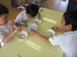 子供達はマイ箸を使って、お豆つかみゲームをしている写真2
