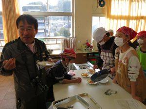 試食する校長先生と生徒たちの写真