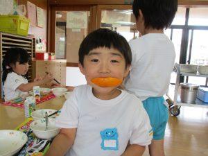 子供がオレンジを食べている写真