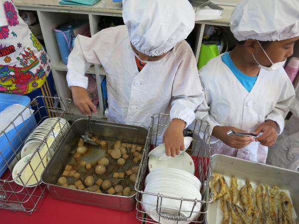 村の里芋の煮物の配膳をする千早小吹台小学校2年生