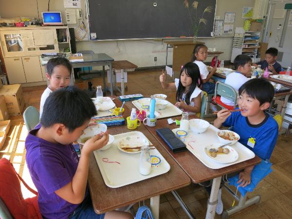 楽しくお話をしながら給食を食べる小学2年生