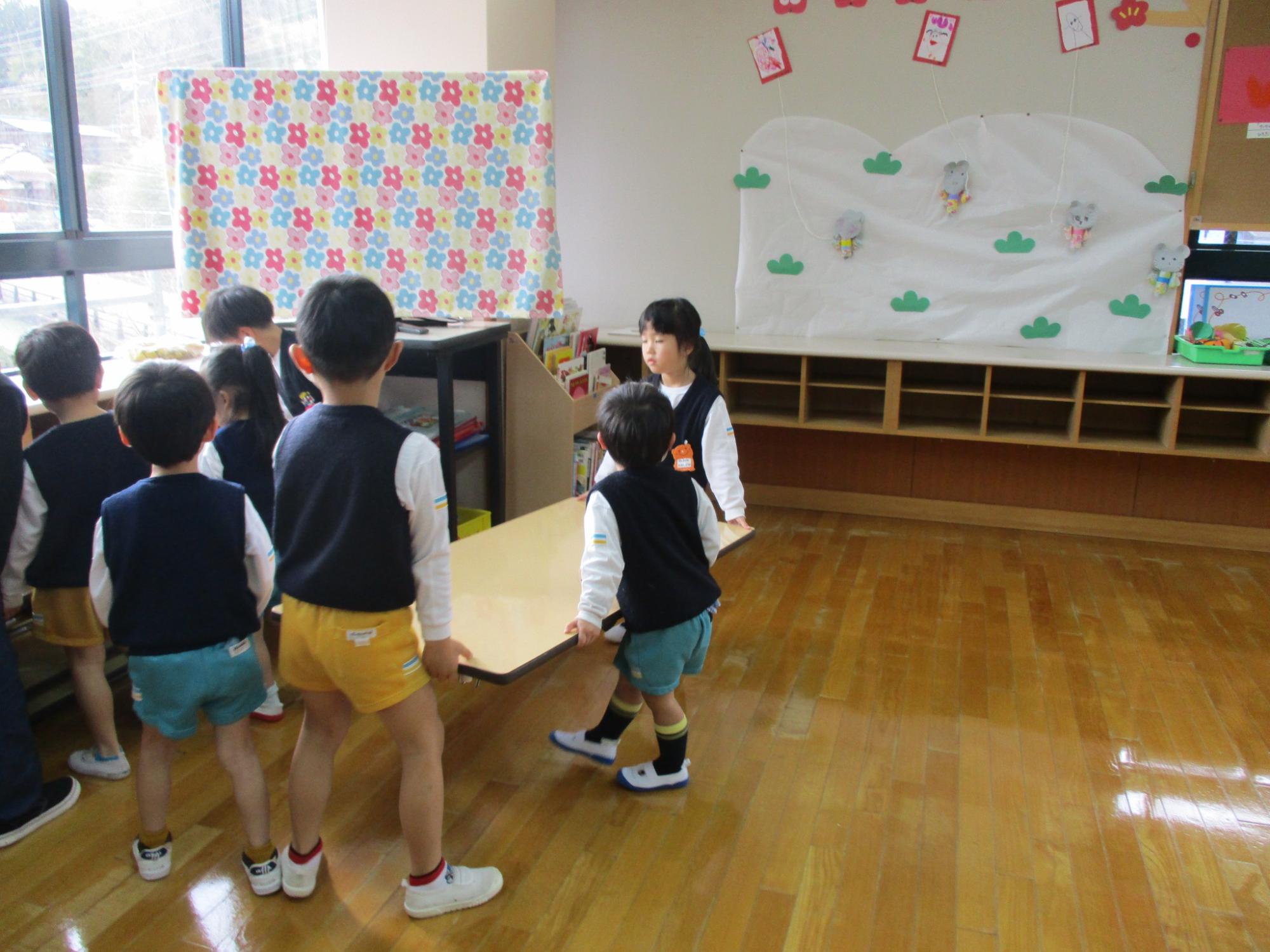 豆つかみゲームをする男子を見守る赤阪小学校4年生