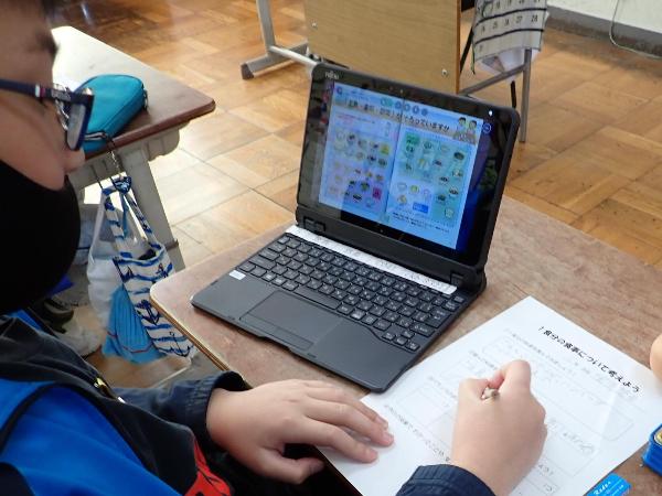 タブレットを使って教材プリントを見る千早小吹台小学校5年生