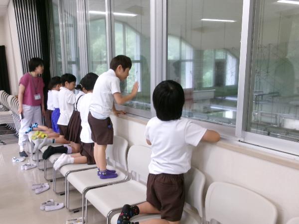 2階の窓から調理室を見る赤阪小学校1年生