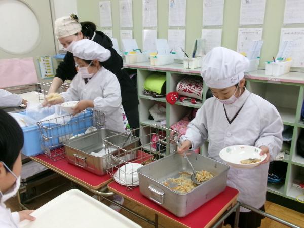担任の先生に教えてもらいながら配膳をがんばる赤阪小学校2年生