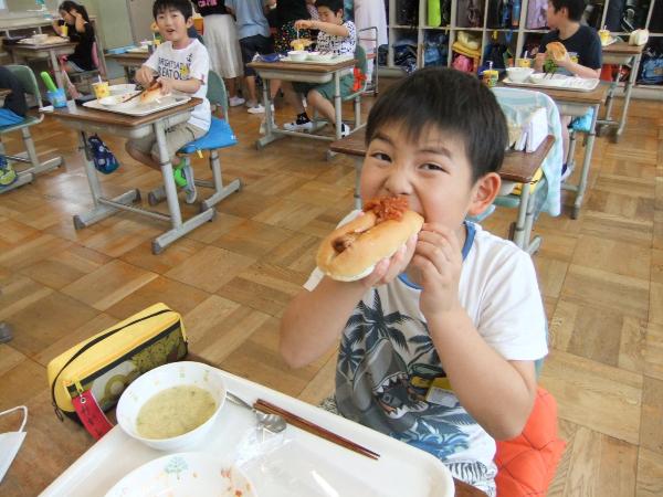 ケチャップフランクをパンに挟んで食べる千早小吹台小3年生