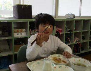 子供がキャベツを箸で掴んでいる写真