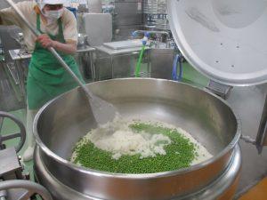 お米を炊いていき、蒸らす直前にえんどう豆を混ぜ込んでいる写真