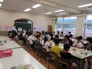 学生たちが座って、ご飯を食べている写真