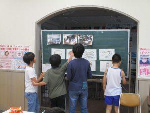 子供達は黒板に張っている紙を見ている写真