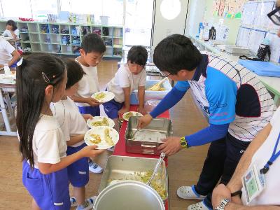 ししゃもの天ぷらの量を先生に調整してもらう小学3年生