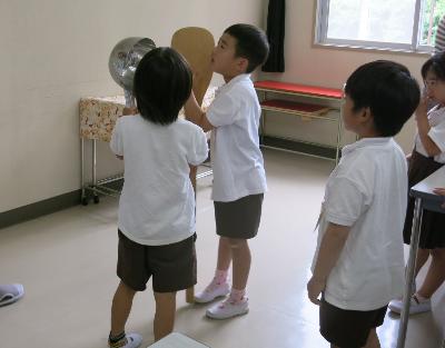 調理用の大きなしゃもじとひしゃくを持ってみる赤阪小学校1年生