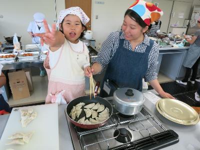 餃子を焼く小学生と保護者