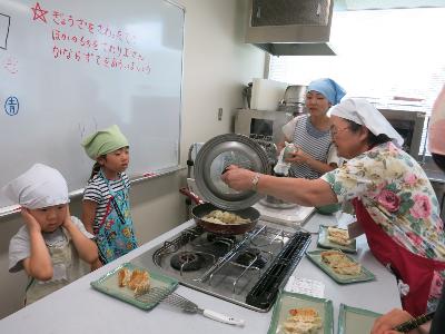 餃子を焼く小学生と保護者