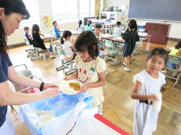 カレーのおかわりをする千早小吹台小学校1年生