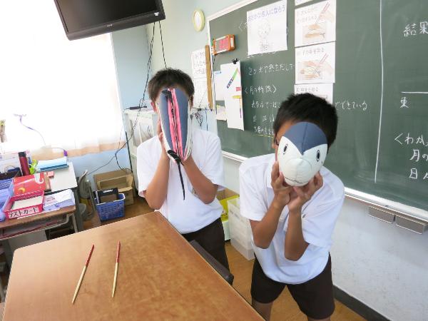 魚のぬいぐるみで遊ぶ小学6年生