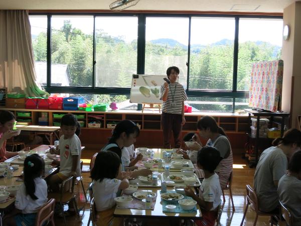 給食の野菜のお話を聞く幼稚園児