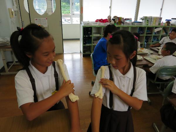 骨のレプリカと自分の腕の長さを比べる赤阪小学校3年生