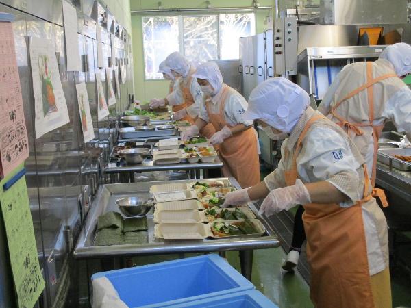 バイキング給食の盛り付けをする調理員さん