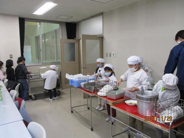 給食センターの会議室で給食の配膳をする千早小吹台小学校1年生