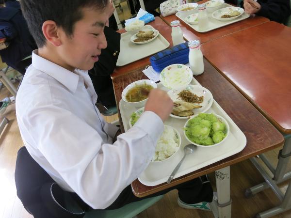 たくさん盛られた給食を元気よく食べる中学2年生