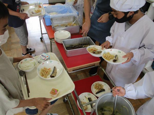 いわしの梅煮を配膳する千早小吹台小学校4年生