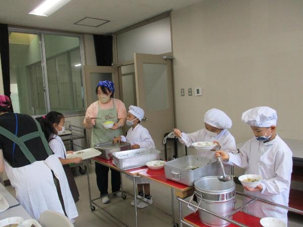 給食センターの会議室で給食の配膳をする赤阪小学校1年生