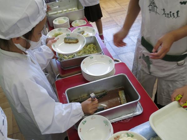 さんまのしょうが煮を配膳する赤阪小学校1年生
