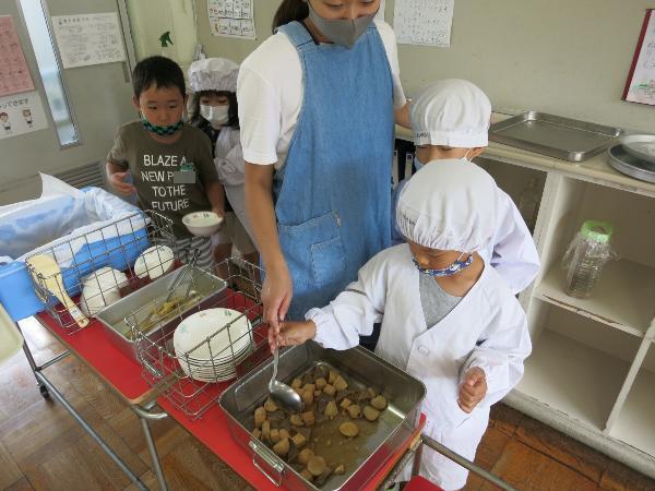 里芋の煮物の盛り付け数を担任の先生に教えてもらう千早小吹台小学校1年生