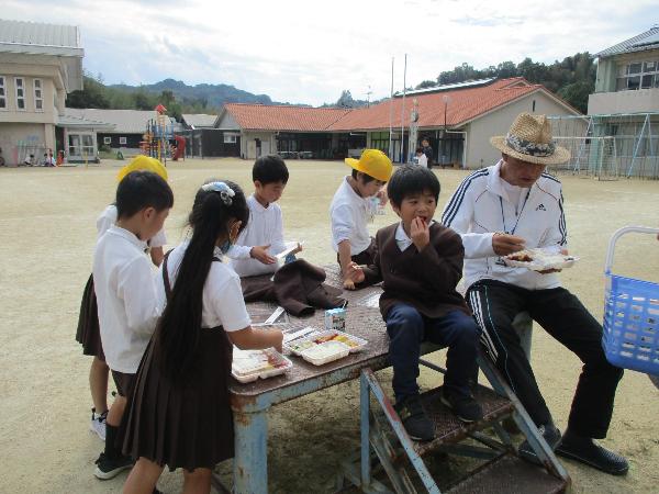 外で弁当給食を食べる赤阪小学校の子ども達