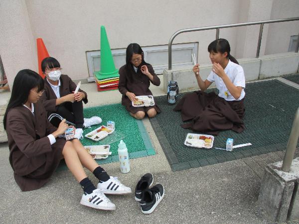 体育館前のスロープで弁当給食を食べる赤阪小学校の子ども達