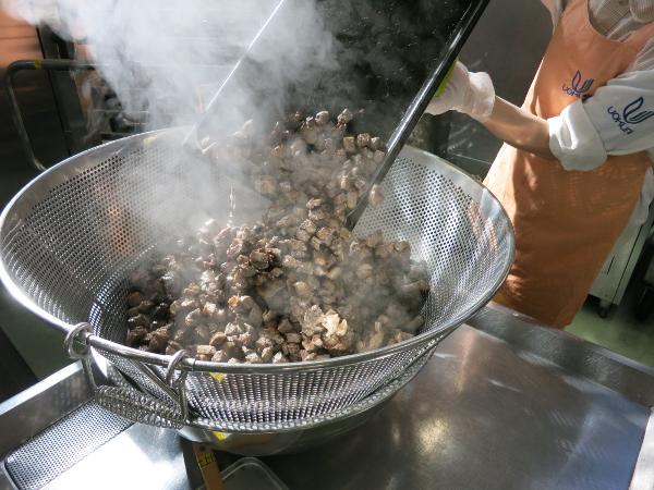焼き上がったサイコロステーキをザルに取り、軽く煮汁を切っている写真