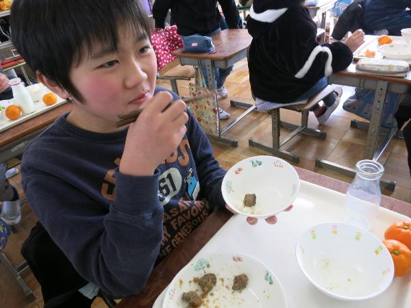和牛サイコロステーキをごはんにのせて食べる児童
