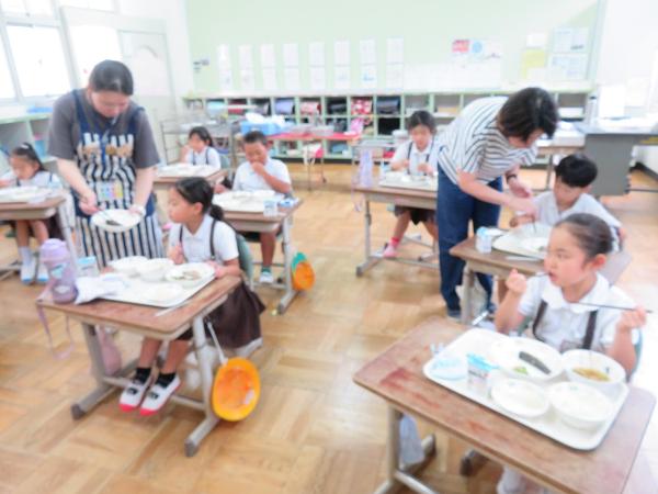 おさかなを上手に食べるのをサポートする担任と栄養教諭