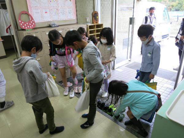 給食センターの玄関できれいに靴を並べる千早小吹台小学校2年生