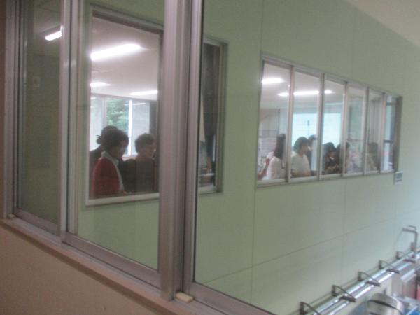 2階の窓から調理場を見学する韓国の学校栄養士さん