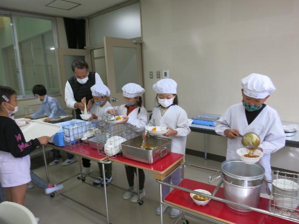 給食センターの会議室で給食の配膳をする千早小吹台小学校2年生