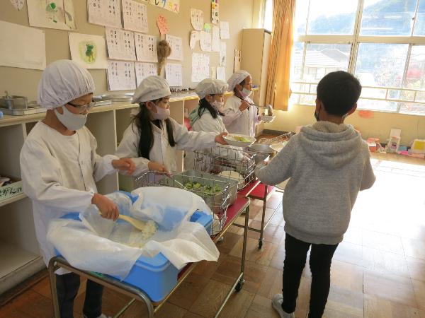 協力して給食の配膳をする、千早小吹台小学校2年生