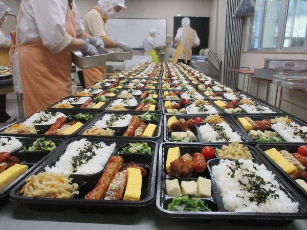 お弁当給食を詰める調理員さん