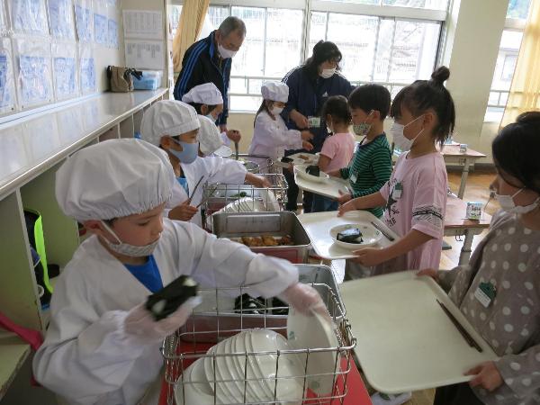 がんばって配膳をしている千早小吹台小学校1年生