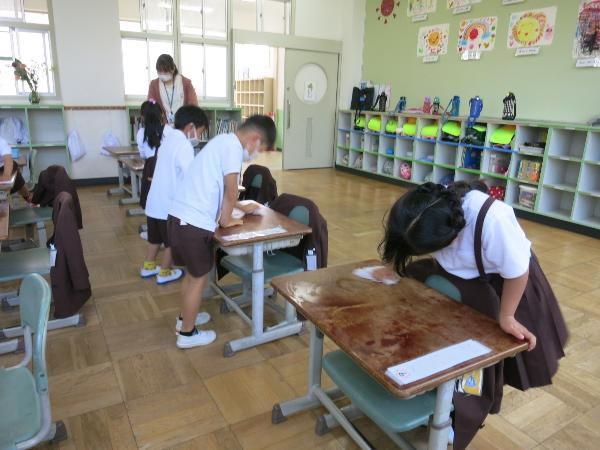ウエットティッシュで机をふく、赤阪小学校1年生