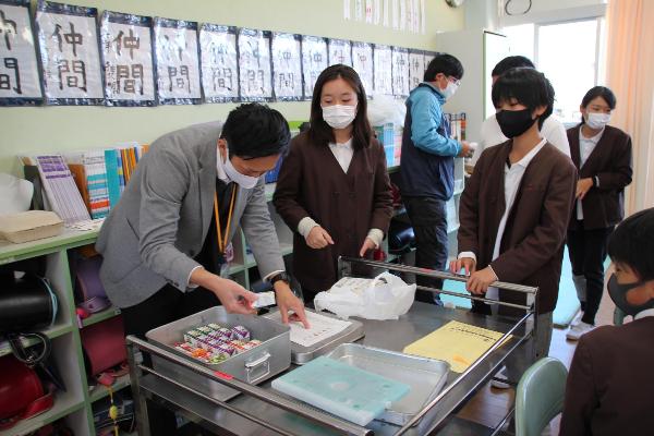 野菜ジュースを渡す、赤阪小学校担任